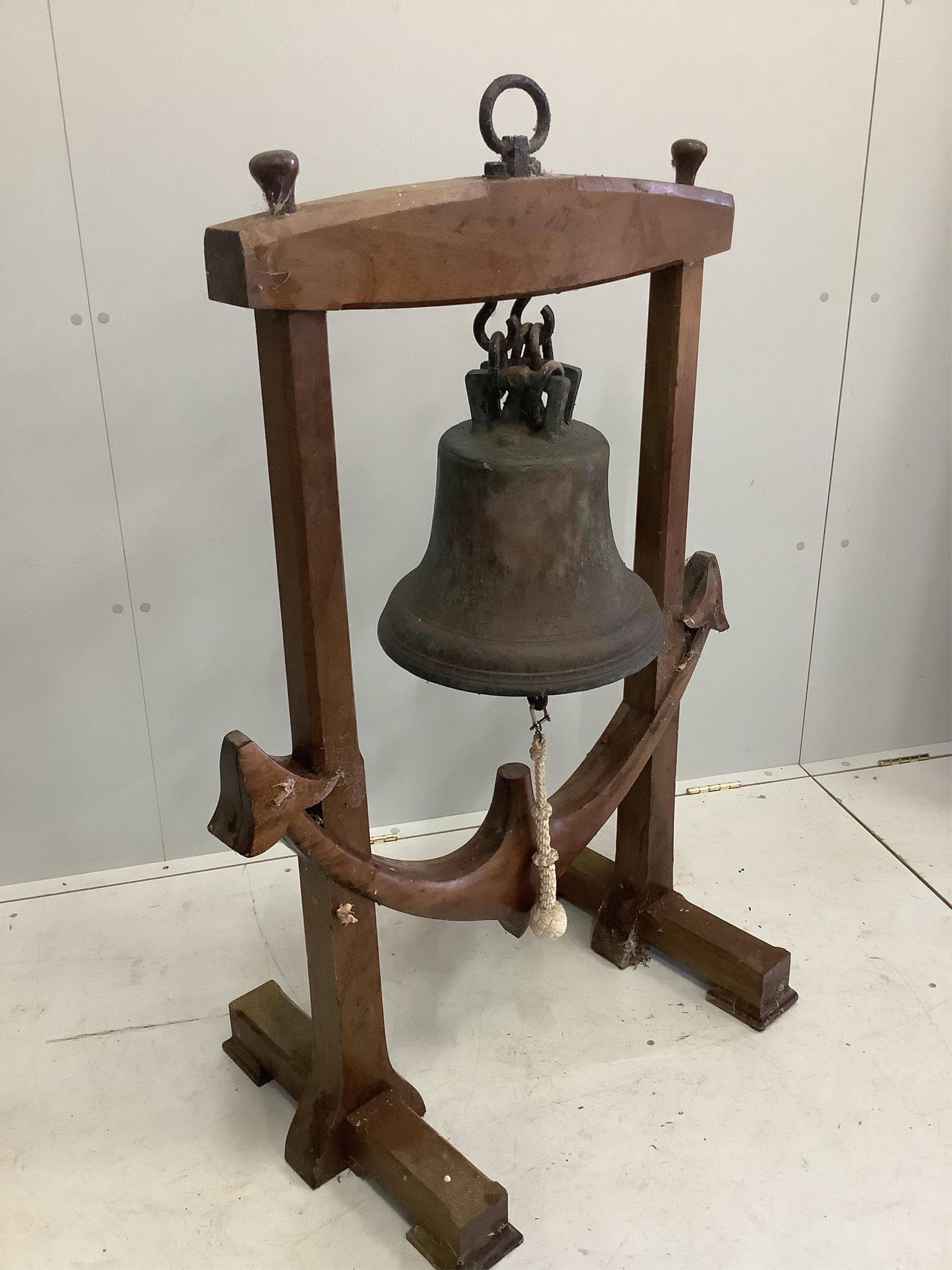 A bronze ship's bell, raised in an anchor shaped wooden frame, height 118cm. Condition